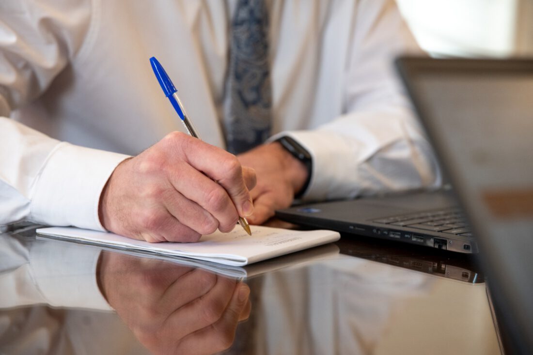 Close-up of a hand writing notes with a pen